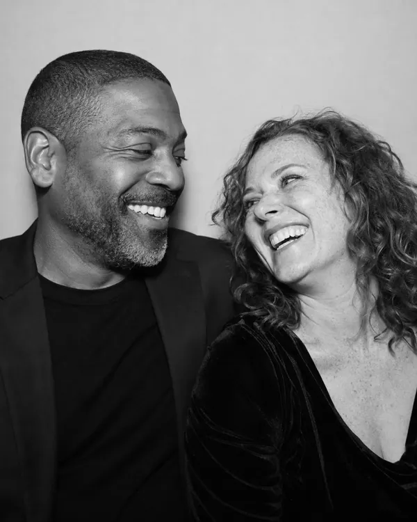Black-and-white glam photo booth portrait of a couple laughing together